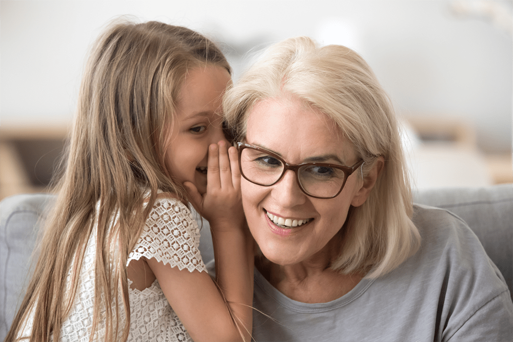 Hearing Aid little girl whispering to grandmother
